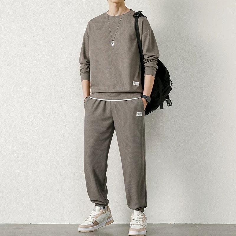 Man wearing loose-fit taupe sweatshirt and joggers set, casual streetwear style