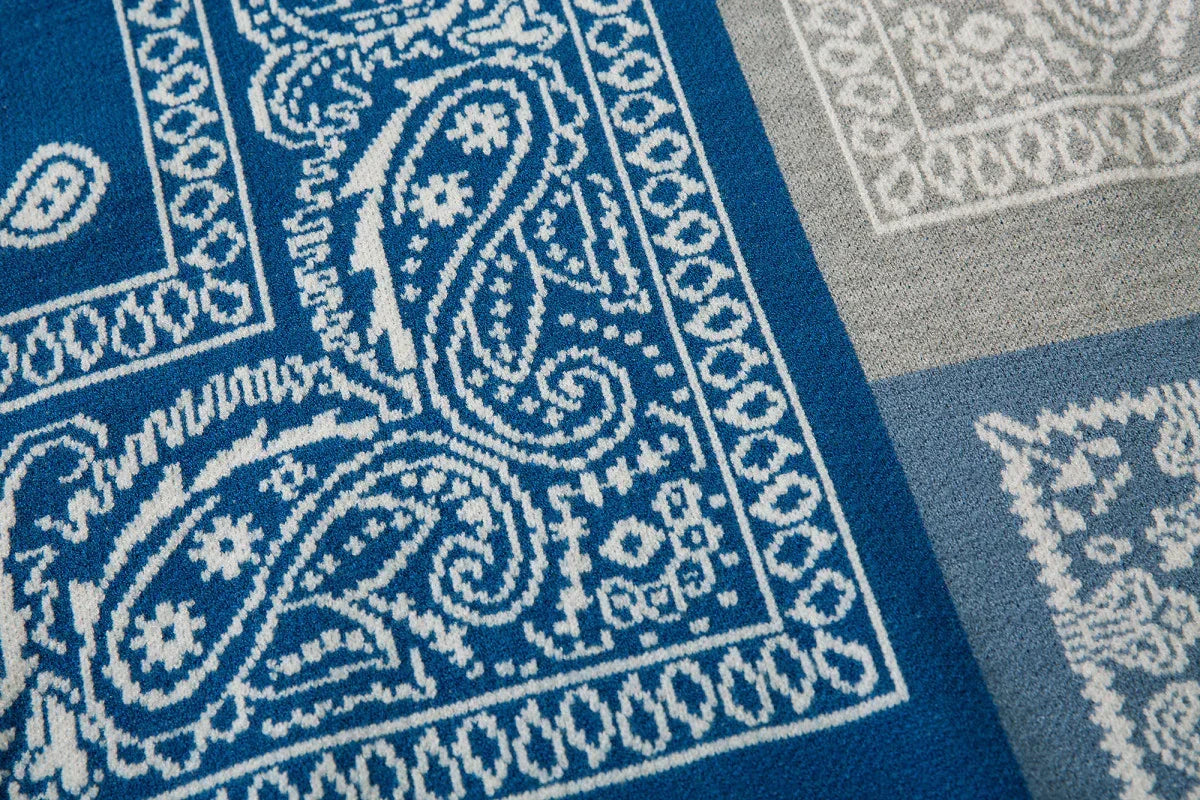 Blue and grey knit fabric with white paisley and geometric streetwear pattern, soft texture