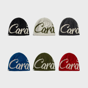 Six knitted beanies in black, white, gray, blue, olive, and red with bold script lettering.