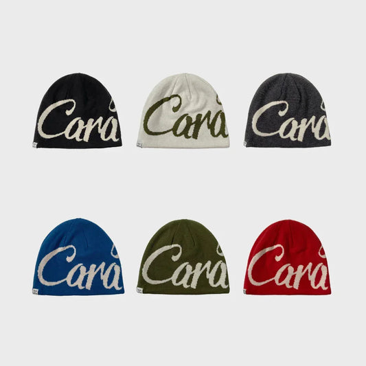 Six knitted beanies in black, white, gray, blue, olive, and red with bold script lettering.