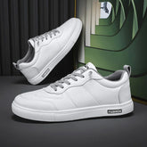 White low-top sneakers with gray laces, synthetic leather, minimalist streetwear style.
