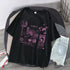 Black oversized graphic t-shirt with purple futuristic prints, paired with light denim shorts