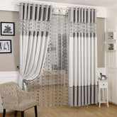 Modern living room with gray and white blackout curtains and sheer polka dot panel.