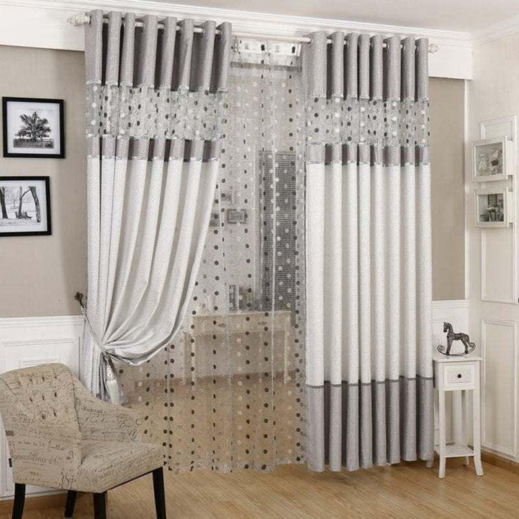 Modern living room with gray and white blackout curtains and sheer polka dot panel.