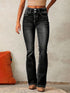 Woman wearing high-waisted black flared jeans with double button closure and white stitching