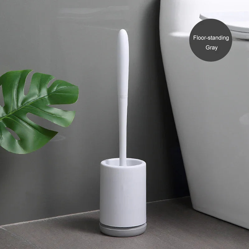 Modern gray floor-standing toilet brush set with sleek white handle beside toilet