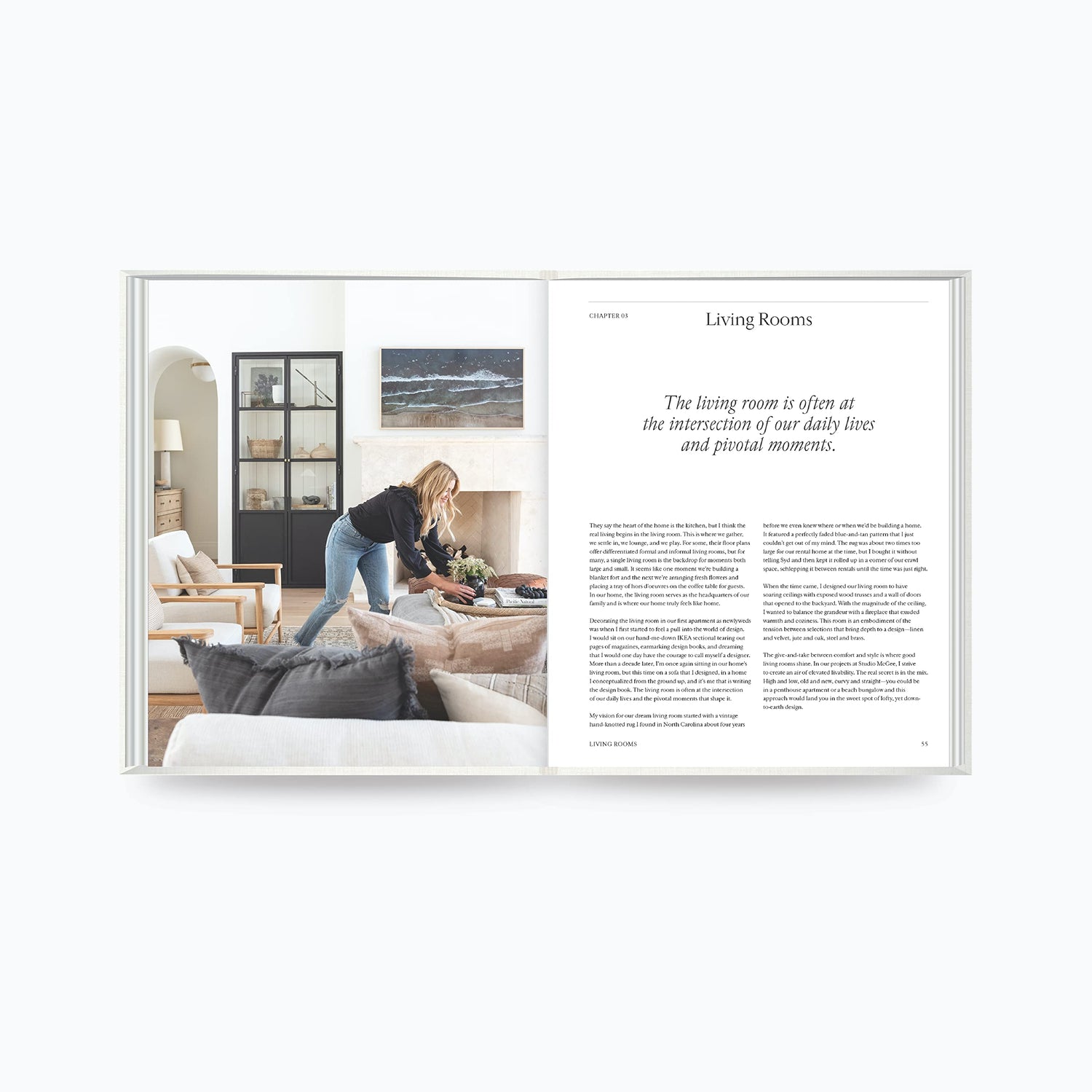 The Art of Home book open to living room design page with woman styling a sofa and modern interior decor by Shea McGee