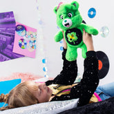 Child playing with 14 inch green Care Bears Rock-a-Lot Good Luck Bear plush with musical belly badge in colorful room
