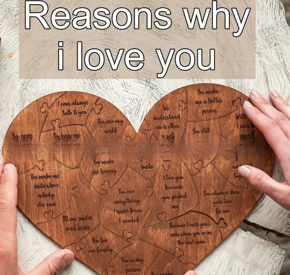 Heart-shaped wooden puzzle with engraved love messages, held by two hands on a neutral surface
