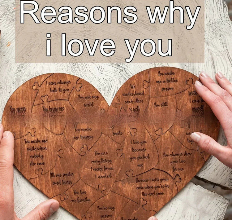 Heart-shaped wooden puzzle with engraved love messages, held by two hands on a neutral surface