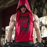 Man at gym wearing sleeveless red hooded muscle tank top with black graphic print, loose fit