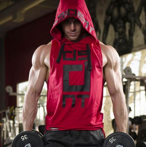 Man at gym wearing sleeveless red hooded muscle tank top with black graphic print, loose fit