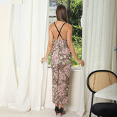 Woman wearing a sleeveless backless midi dress with floral and leopard print, slim fit.