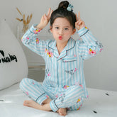 Girl wearing light blue and white striped long-sleeve cartoon print pajamas, relaxed fit