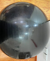 Black exercise stability ball with glossy finish on a wooden floor