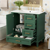 Modern green bathroom vanity with gold handles, white countertop, open drawers and cabinets showing towels and toiletries, contemporary interior setting.