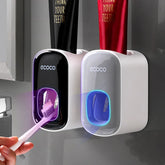 Wall-mounted automatic toothpaste dispensers in black and white with toothbrush under UV light