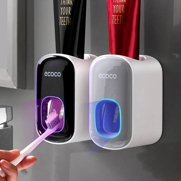 Wall-mounted automatic toothpaste dispensers in black and white with toothbrush under UV light