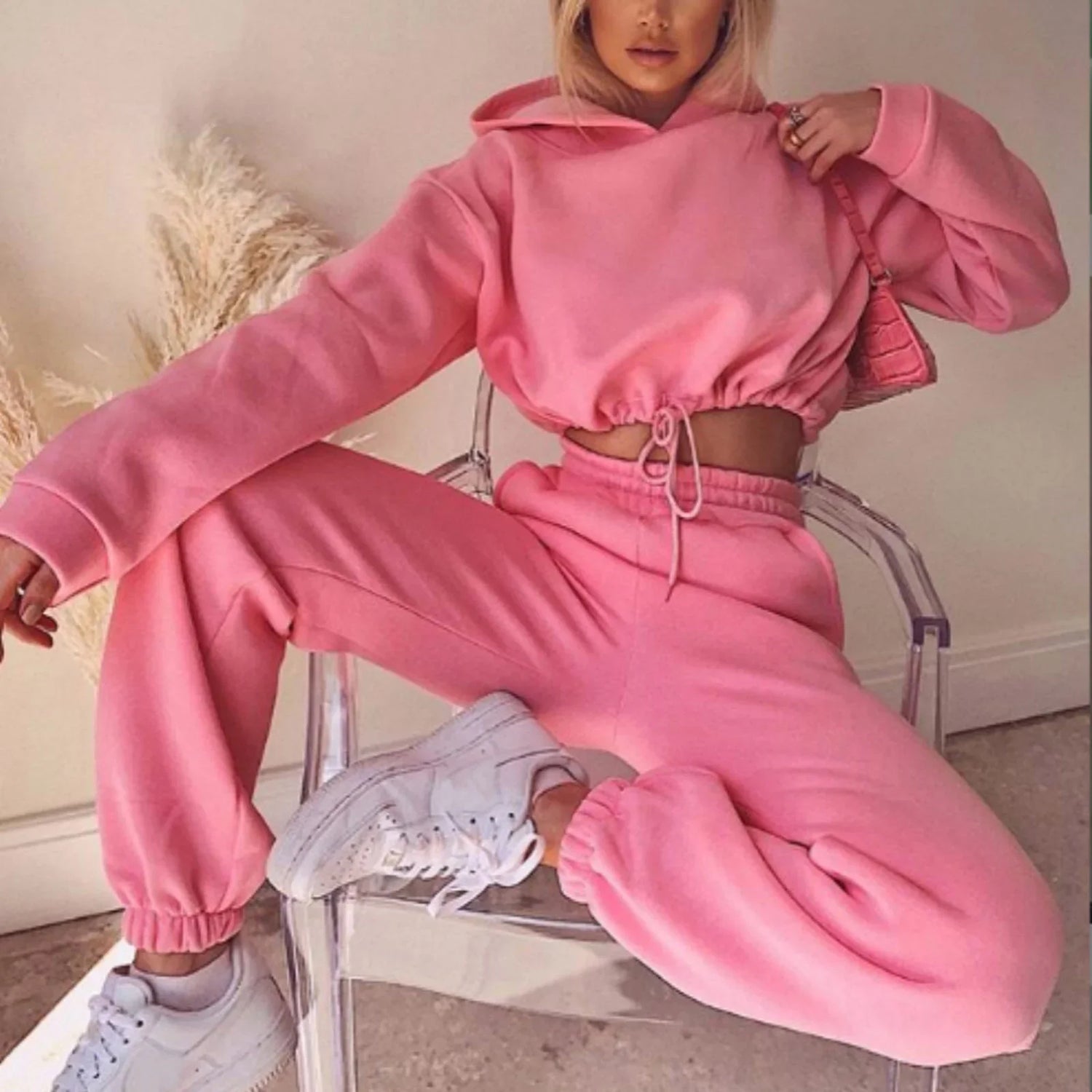 Woman wearing pink oversized hoodie and matching joggers, relaxed fit, soft fleece fabric