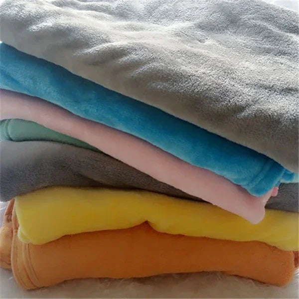 Stack of soft fleece blankets in gray, blue, pink, yellow, and orange colors