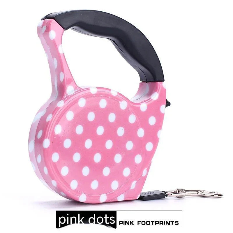 Retractable dog leash with pink and white polka dot pattern, ergonomic black handle