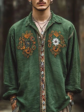 Man wearing loose fit green linen shirt with colorful floral embroidery and button details