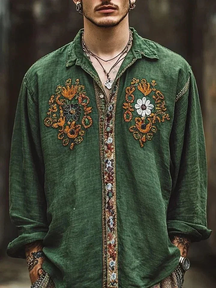 Man wearing loose fit green linen shirt with colorful floral embroidery and button details