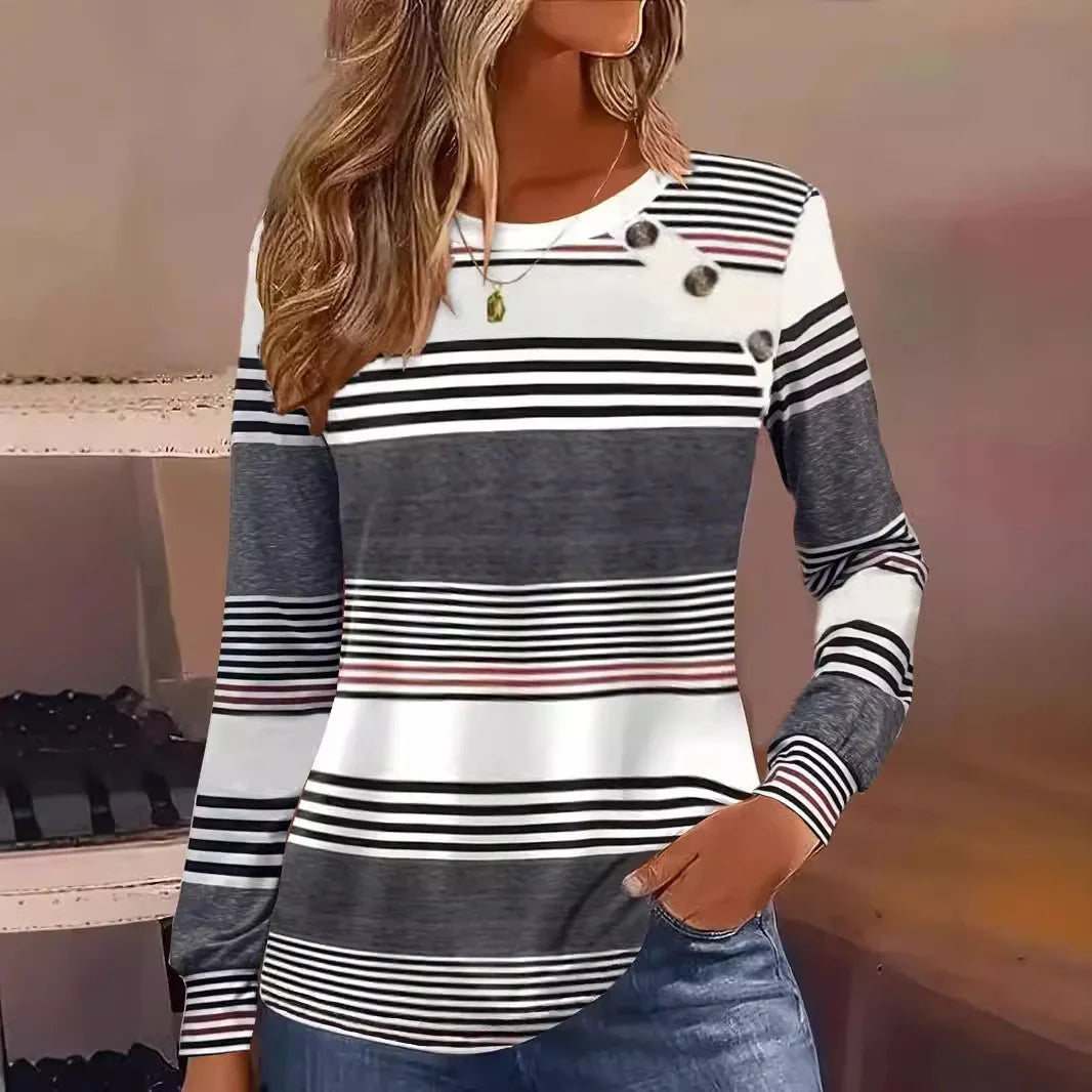 Woman wearing a long sleeve striped pullover in black, white, and gray with relaxed fit