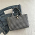 Black and white gingham tote bag with rope closure on denim jacket, casual streetwear style
