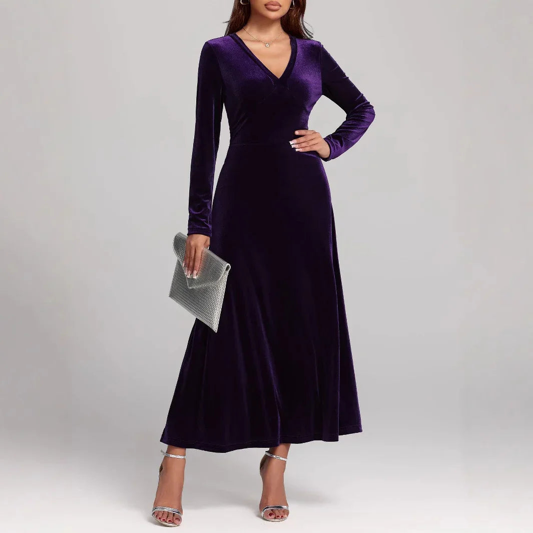 Woman in a long-sleeve, deep purple velvet maxi dress with a flattering fit and V-neckline