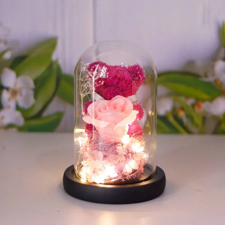 Decorative glass dome with pink rose, preserved flowers, and plush bear, warm white LED lights