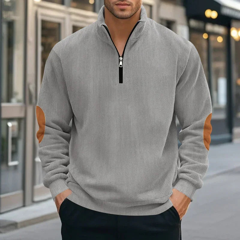 Men’s light gray ribbed pullover with brown suede elbow patches, half-zip, relaxed fit.