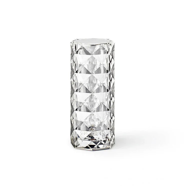 Clear geometric faceted glass tumbler on a white background