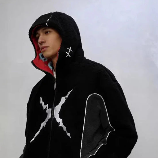 Man wearing black fleece hooded jacket with white lightning graphic and red lining, streetwear style.