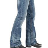 Blue distressed flared denim jeans with relaxed fit and textured wash, paired with black boots