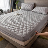 Gray quilted mattress cover with diamond stitching, soft material, fitted design, modern bedroom