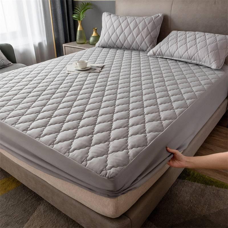 Gray quilted mattress cover with diamond stitching, soft material, fitted design, modern bedroom