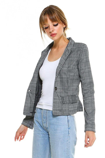 Woman wearing a fitted gray plaid blazer over a white tank top and light blue jeans
