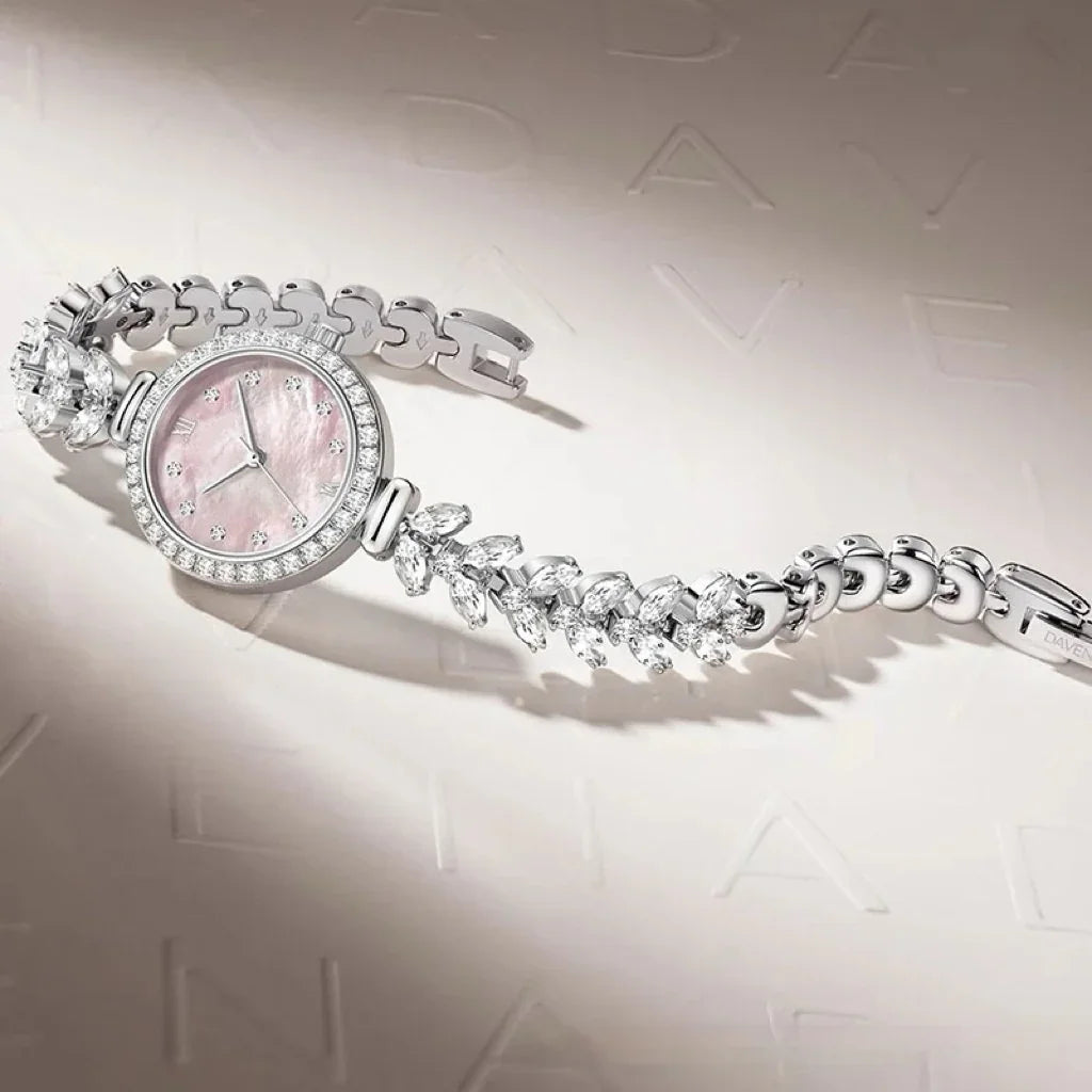 Elegant silver watch with pink mother-of-pearl face, crystal accents, and a jeweled bracelet