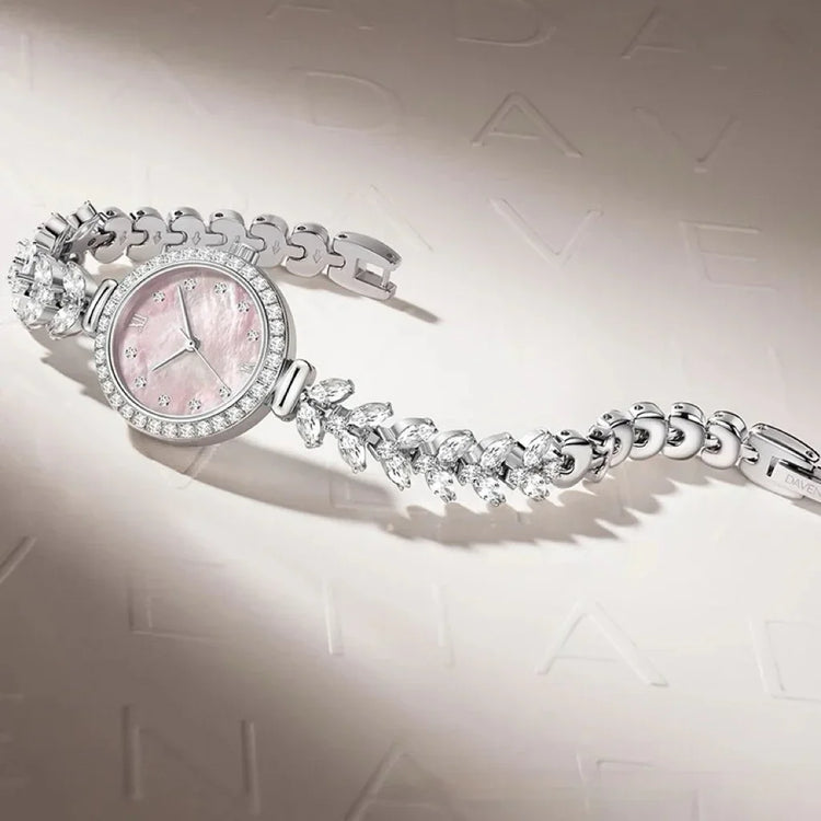 Elegant silver watch with pink mother-of-pearl face, crystal accents, and a jeweled bracelet