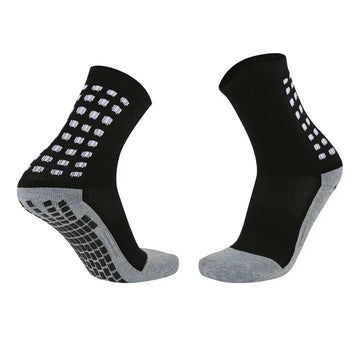Black and gray athletic crew socks with white grip dots, ribbed material, and cushioned soles.