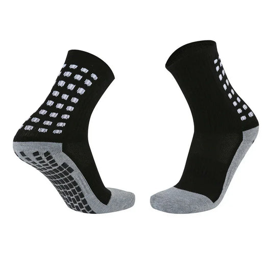 Black and gray athletic crew socks with white grip dots, ribbed material, and cushioned soles.