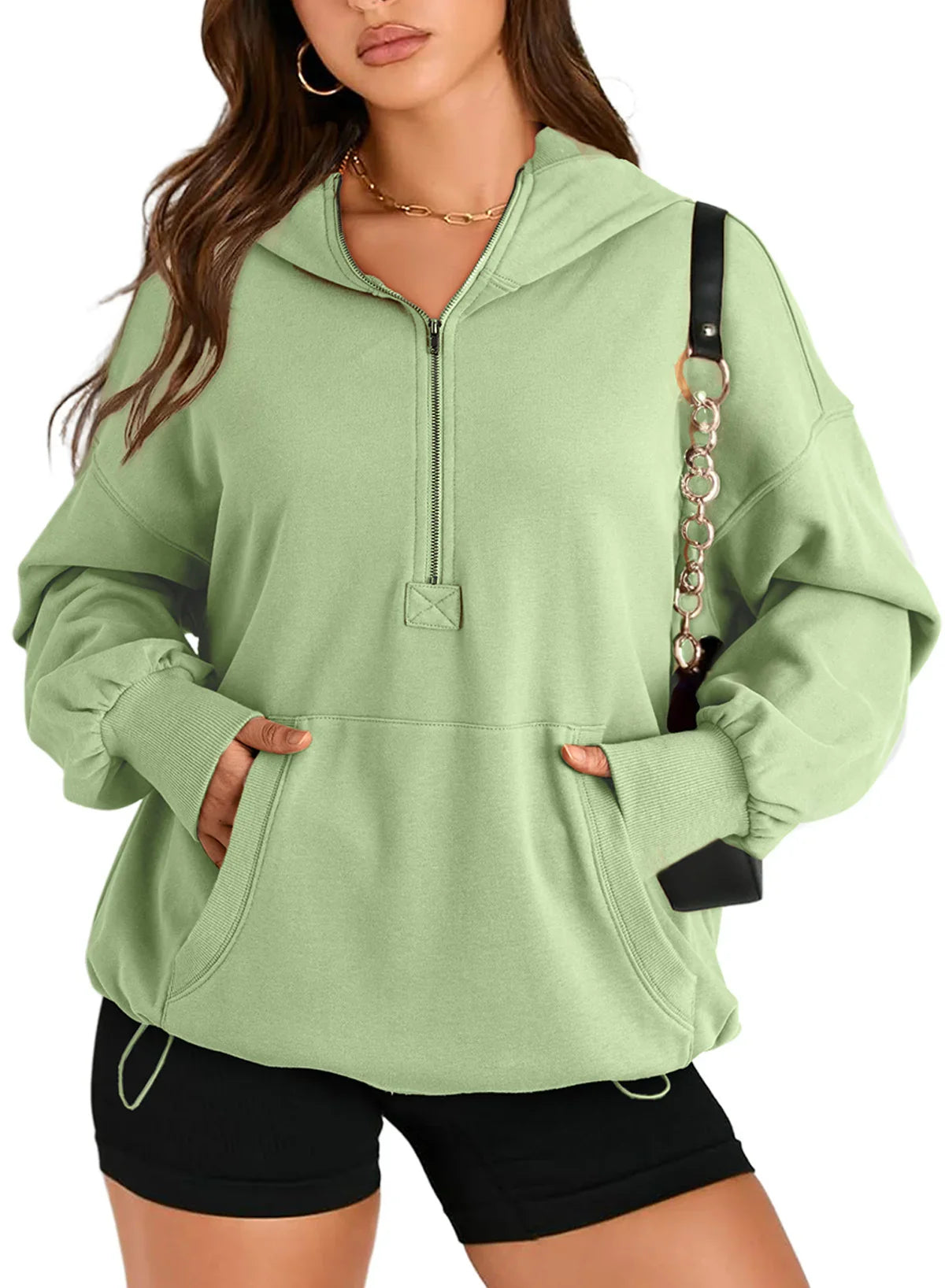 Light green oversized hoodie with kangaroo pocket, half-zip, paired with black shorts