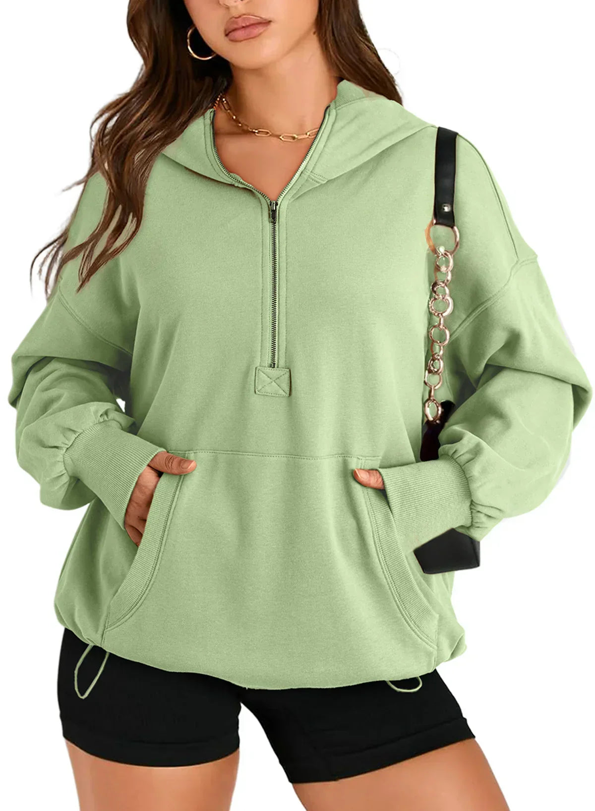 Light green oversized hoodie with kangaroo pocket, half-zip, paired with black shorts