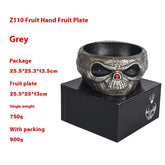 Grey skull-shaped fruit bowl with textured finish, round fit, displayed on a black box.
