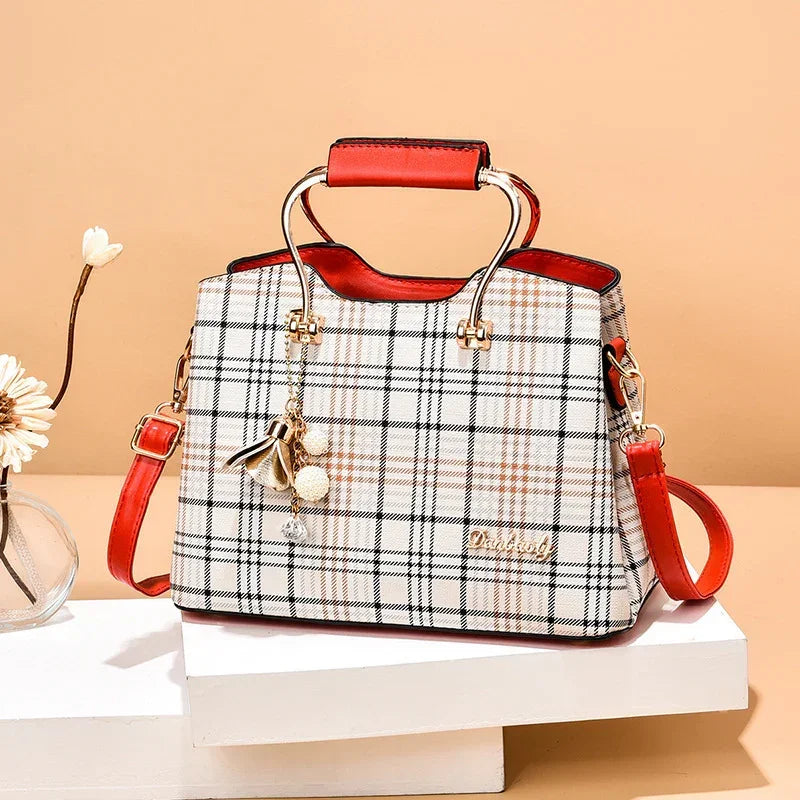 Plaid handbag with red leather handles and trim, gold hardware, and detachable strap