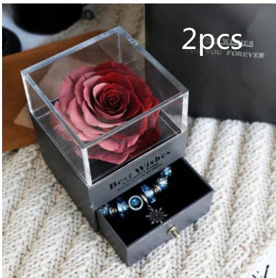 Red preserved rose in clear acrylic box with drawer containing beaded bracelet, gift set