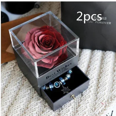 Red preserved rose in clear acrylic box with drawer containing beaded bracelet, gift set