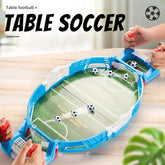 Mini tabletop soccer football game with blue plastic frame and small soccer balls, hands playing