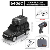 Black remote control camera car toy with camera module, two white trailers, controller, USB accessories, and carrying case.